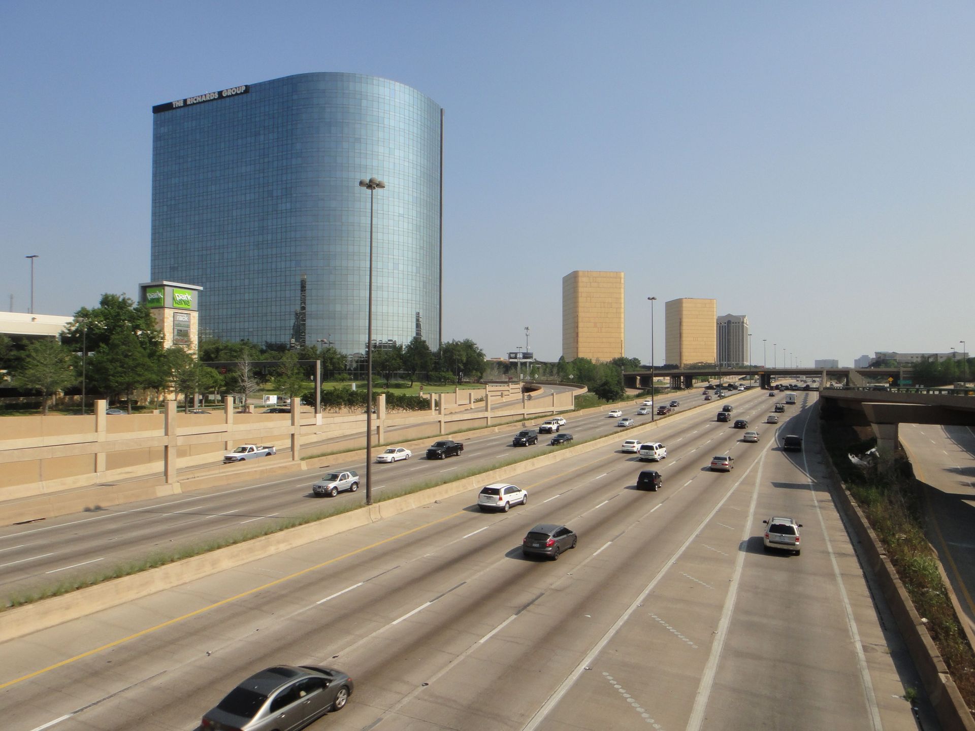 Cars on a busy Texas highway with a city skyline, illustrating high-risk auto insurance for DFW driv