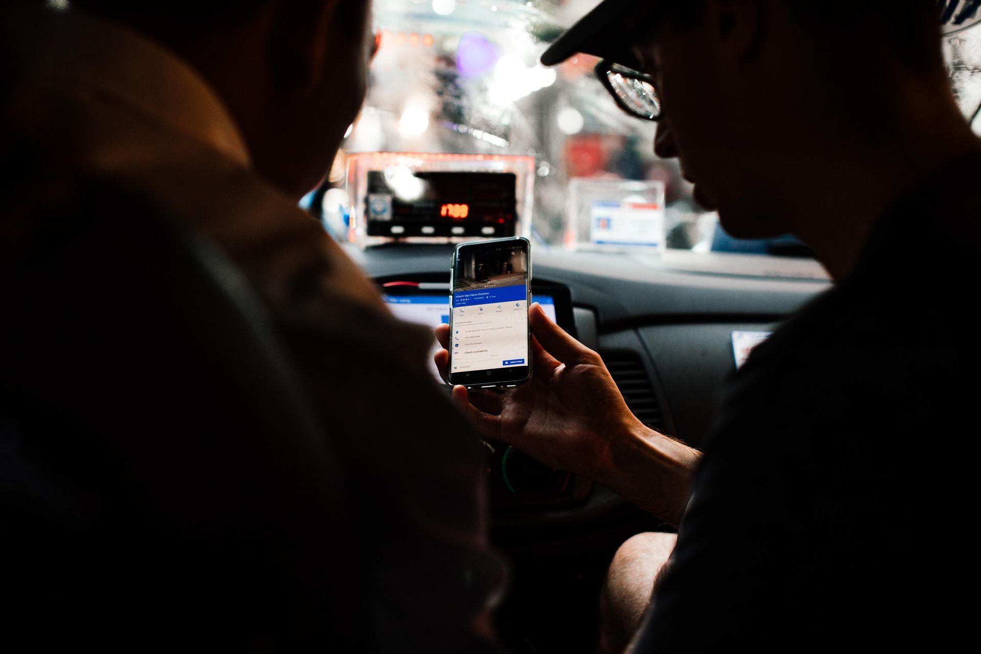 Uber and DoorDash rideshare driver using a phone in a car in Dallas-Fort Worth, Texas, needing special auto insurance coverage