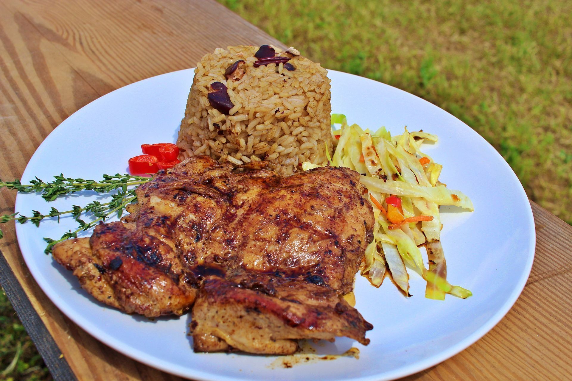 Plate with grilled chicken, rice, and fried vegetables.