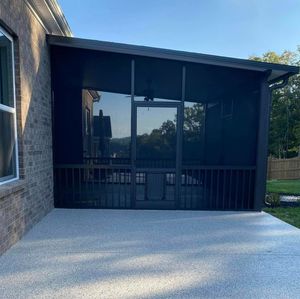 A screened in porch with a brick building in the background.