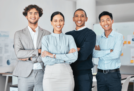 Four diverse business professionals, arms crossed, smiling confidently in an office setting.