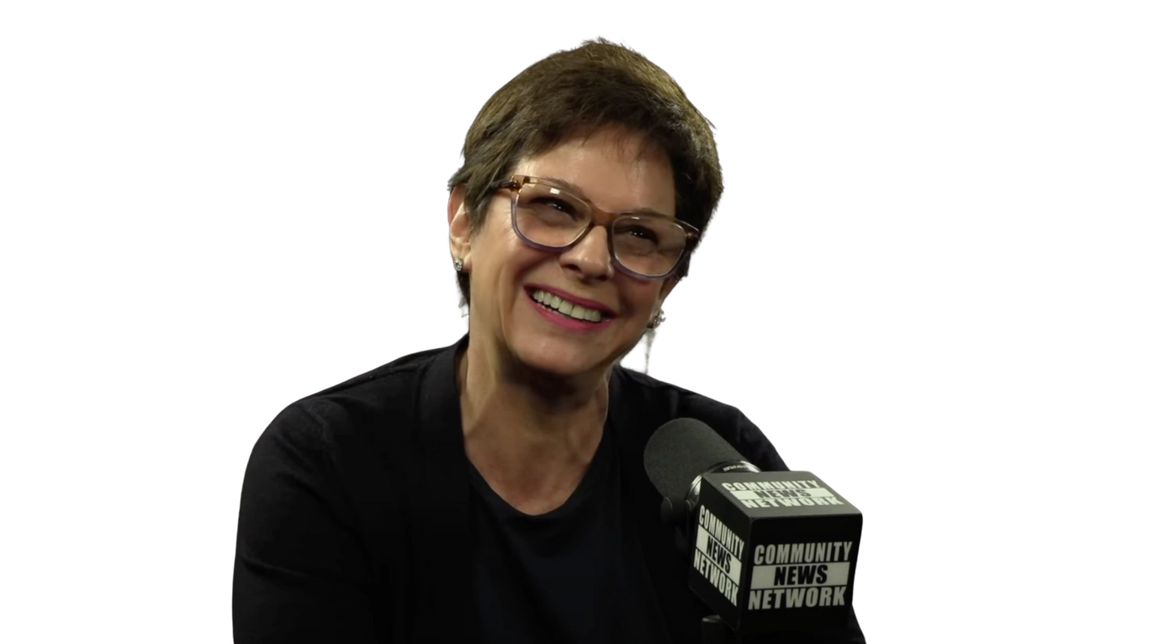 CNEWS TV Woman with glasses and short brown hair smiles while speaking into a microphone.