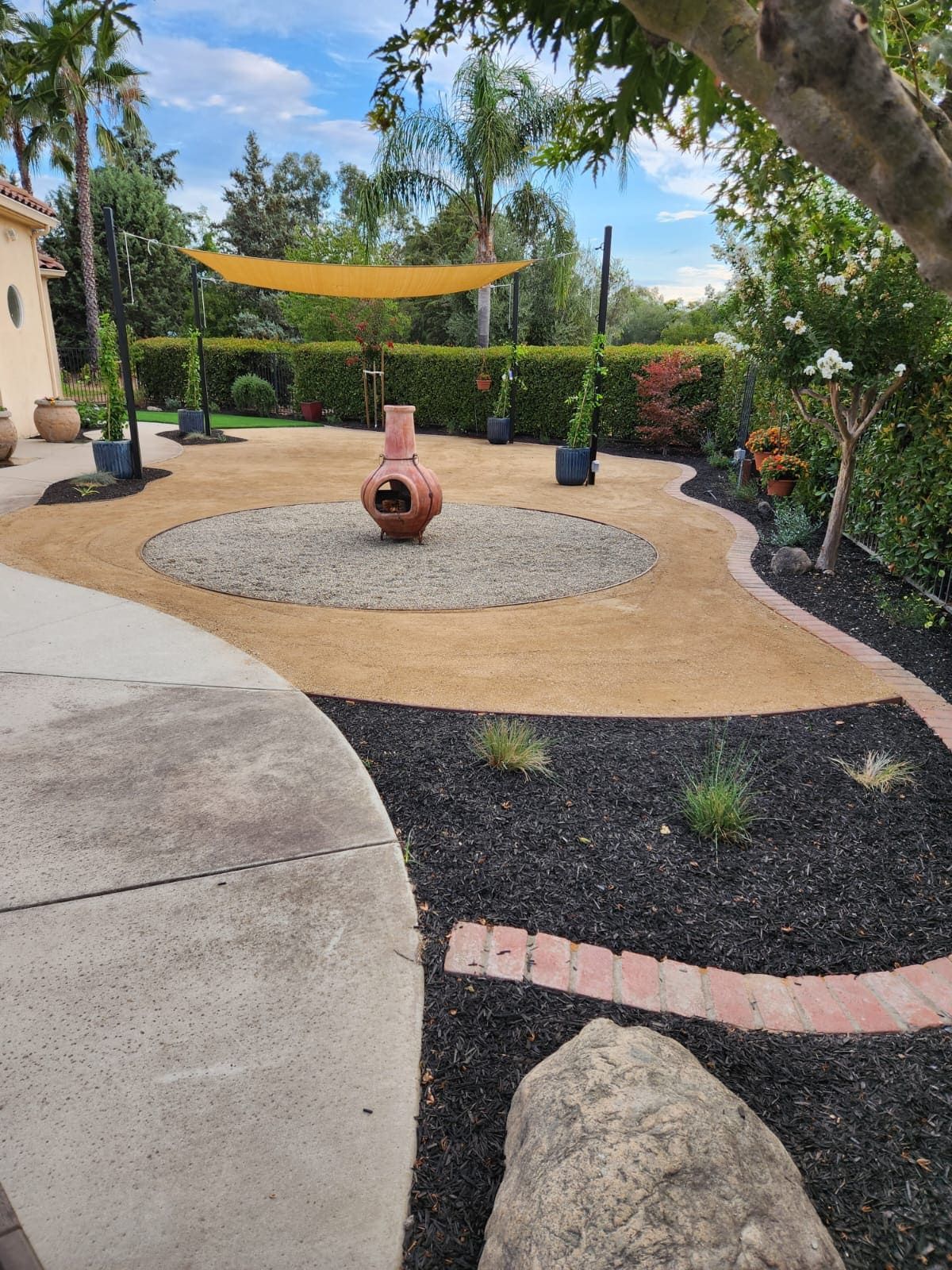 Full landscape design with concrete, plants, turf and rock in Stockton CA.
