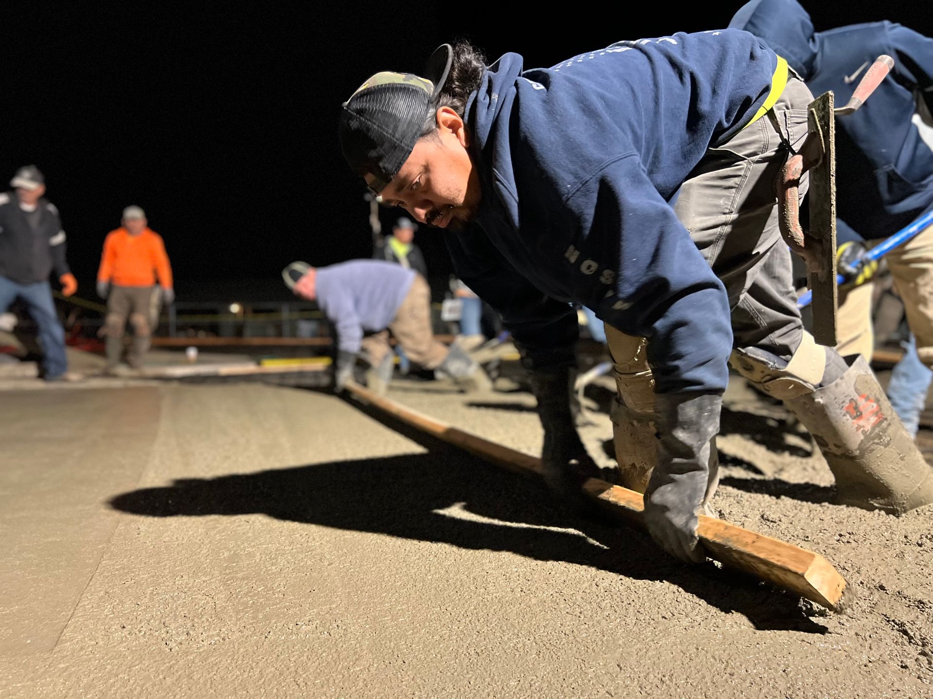 Professional crew leveling and finishing a concrete driveway during installation at a Stockton home