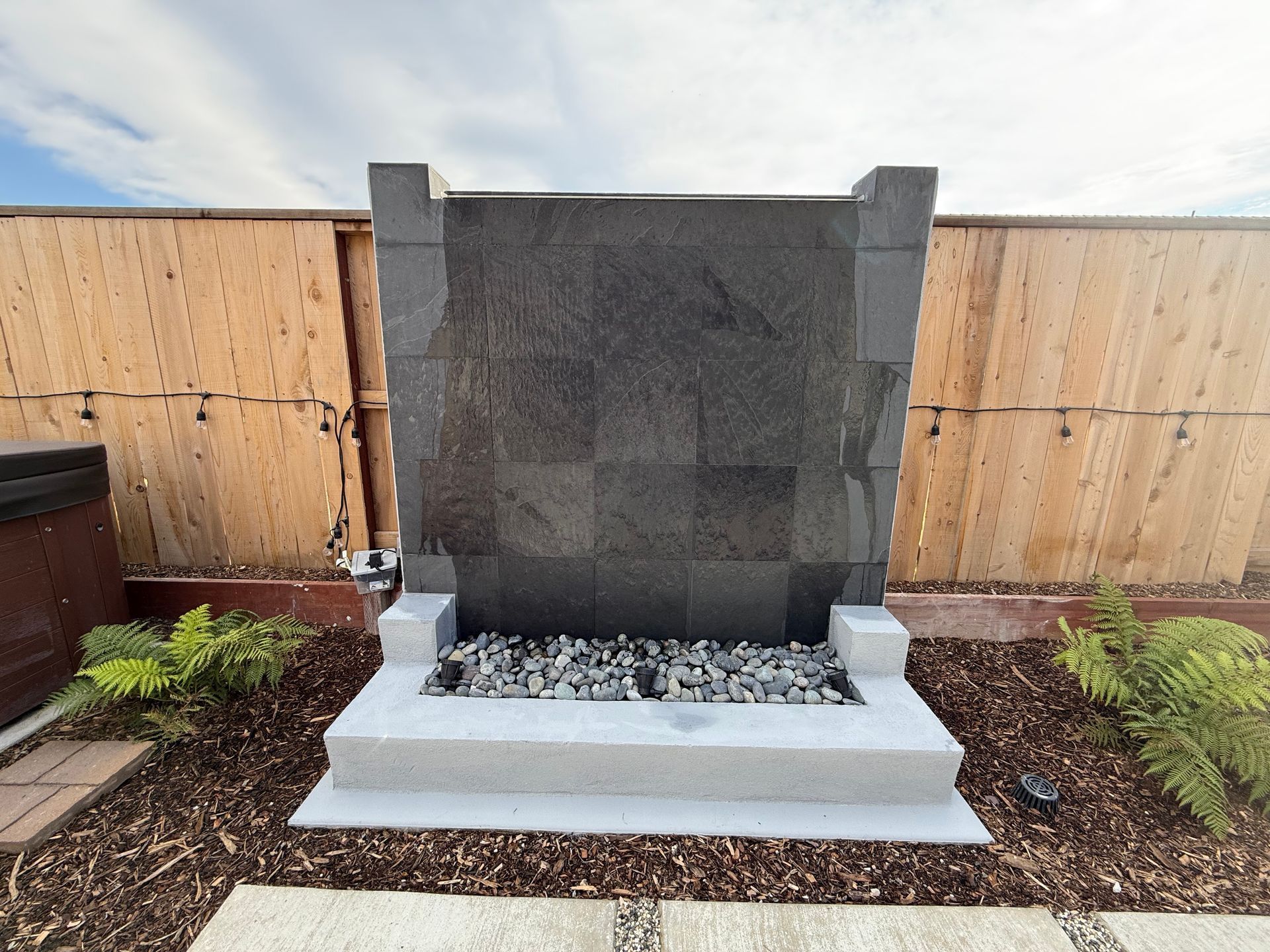 Concrete and decorative rock fountain installation in Stockton landscape.
