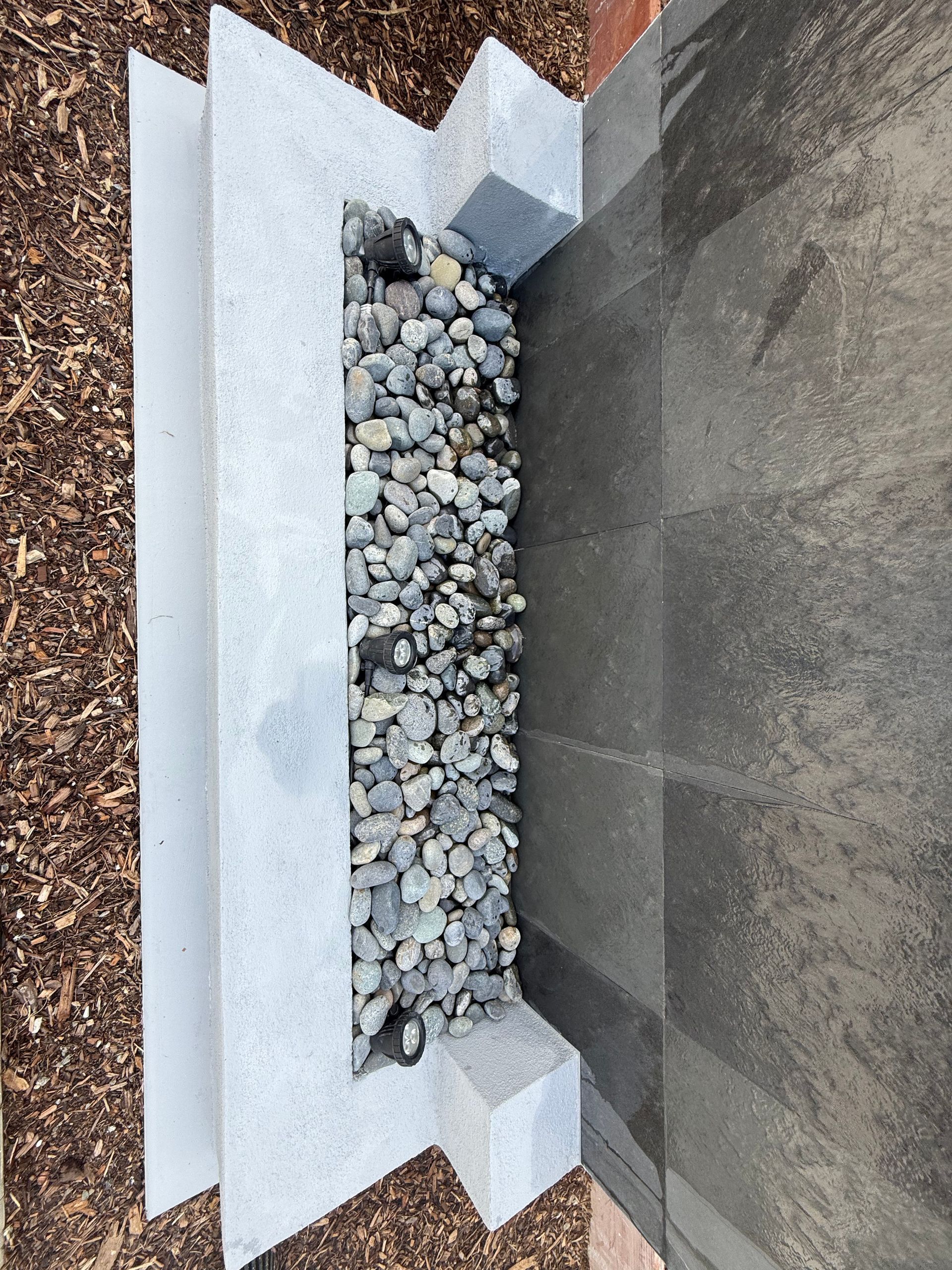 Close-up of rock, concrete, and mulch used in landscape design.