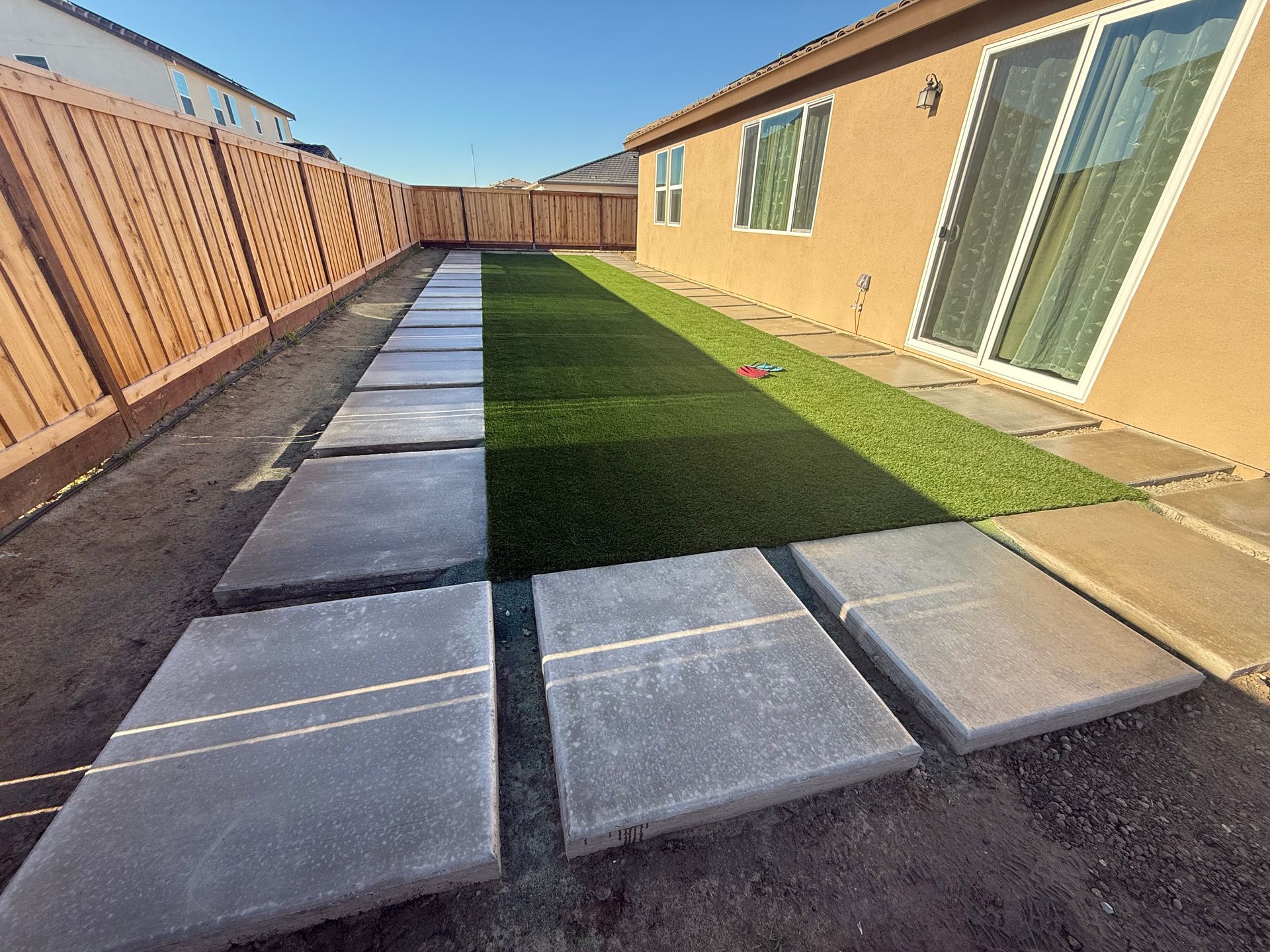 Landscape design with concrete path and turf installation in Stockton.