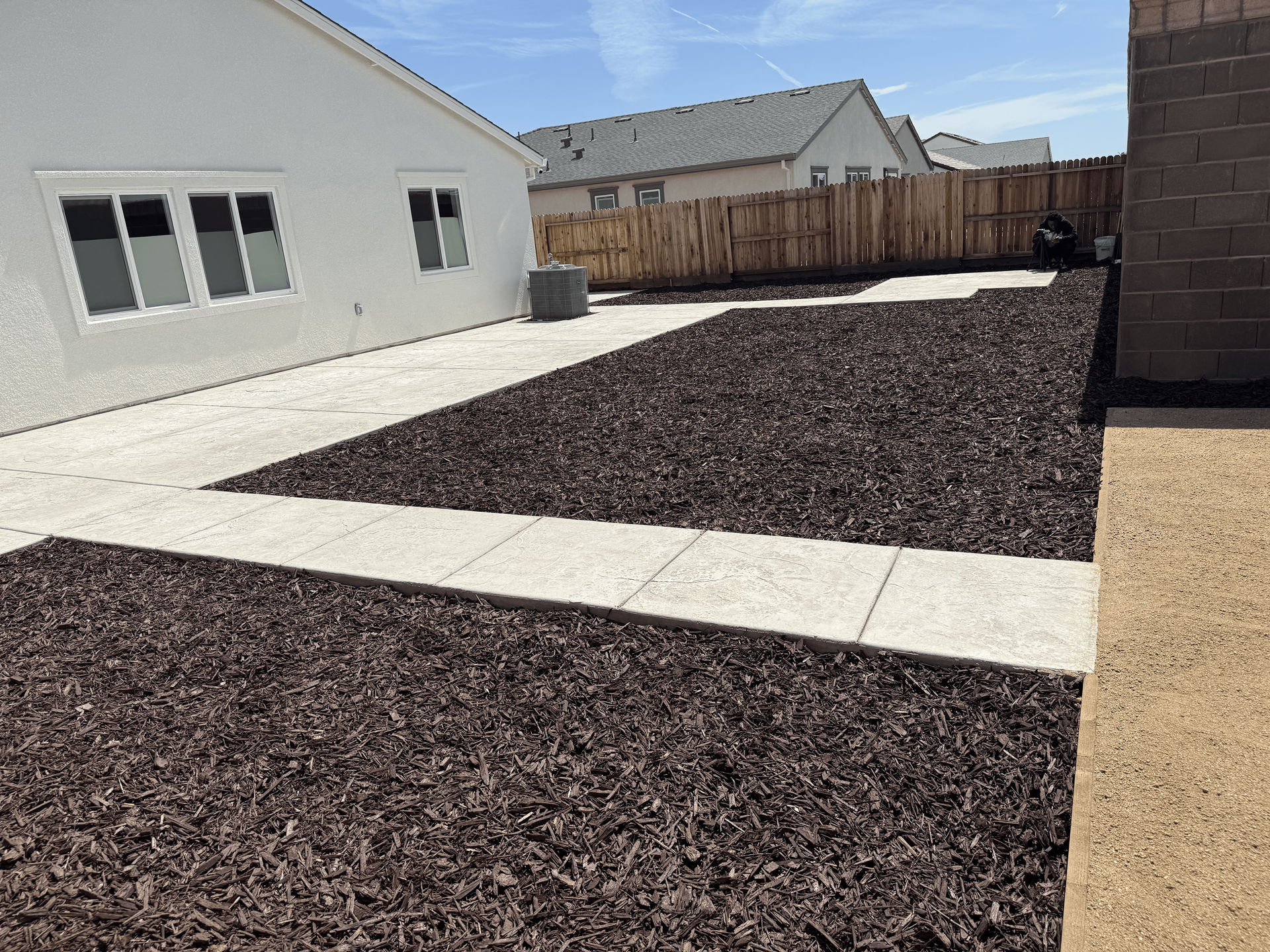 Decorative mulch ground cover surrounding a backyard patio in a Stockton home