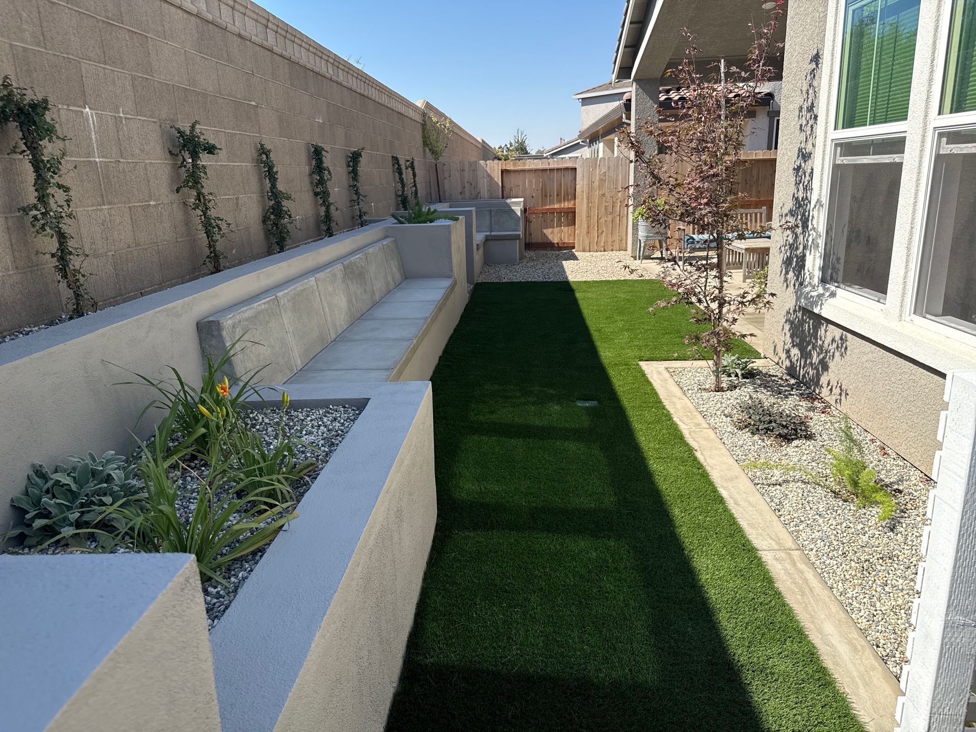 Custom built-in concrete seating area installed as part of a backyard patio design