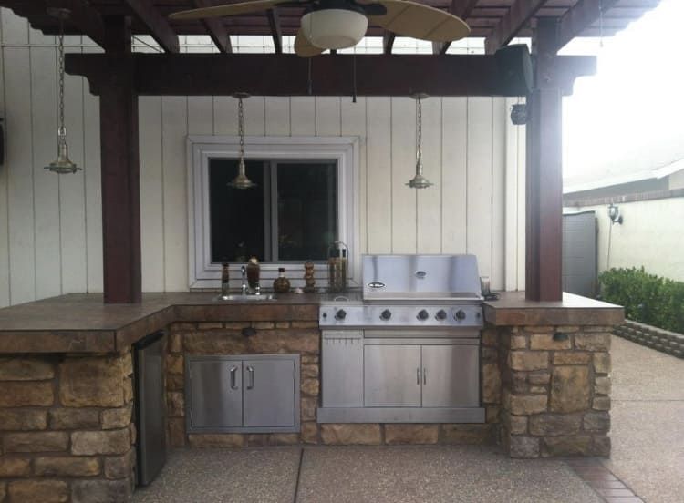 Custom outdoor kitchen built on a Stockton patio with concrete counters and stainless steel grill