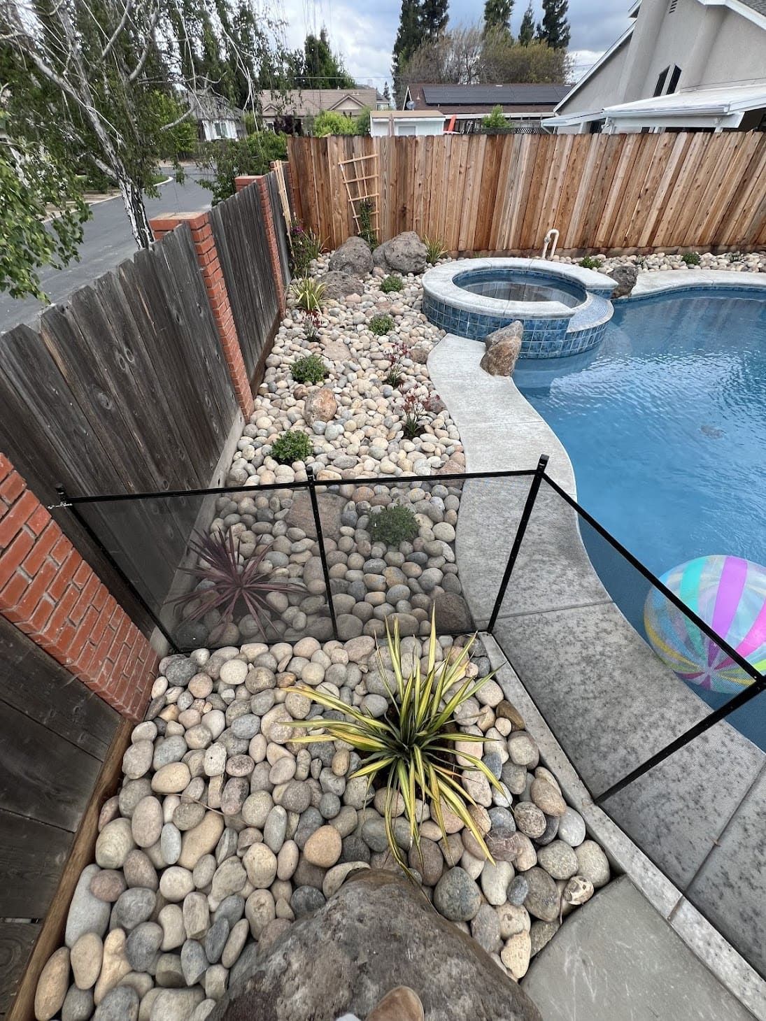 Decorative rock landscaping around backyard pool in Stockton.
