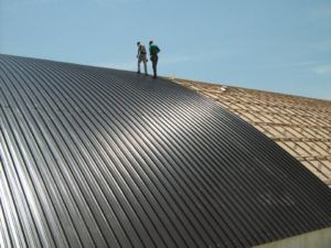 uomini su un tetto con pannello in metallo