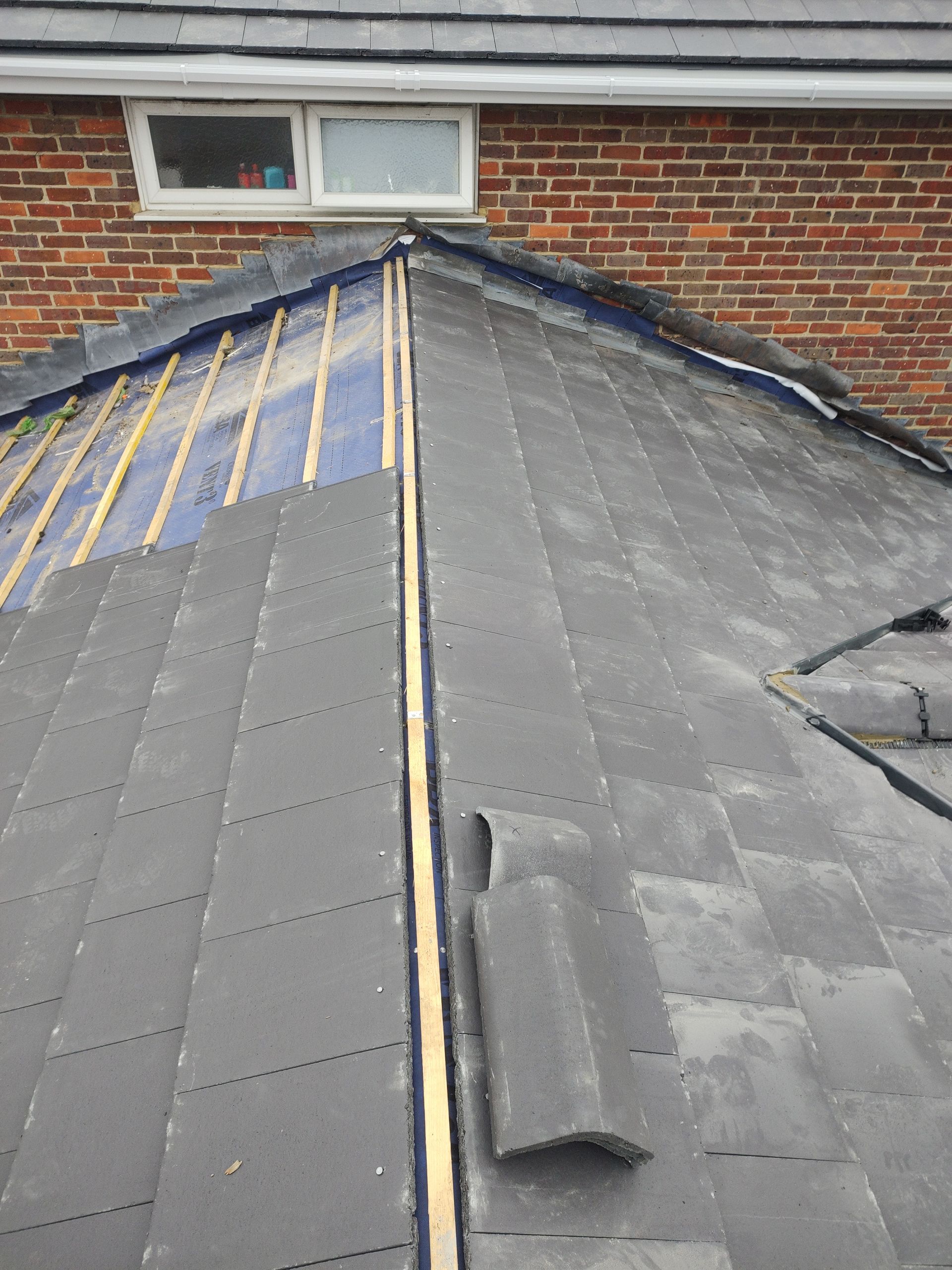 A roof is being installed on a brick house by roofers in Bicester, M&C Roofing.