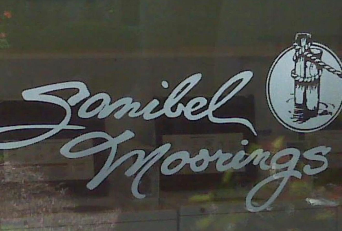 Sanibel Moorings logo on glass door; silver script lettering and nautical illustration.