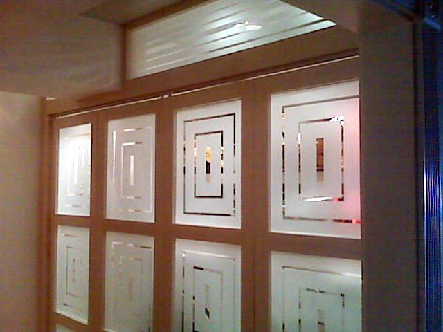Wooden door panels with frosted glass geometric designs.
