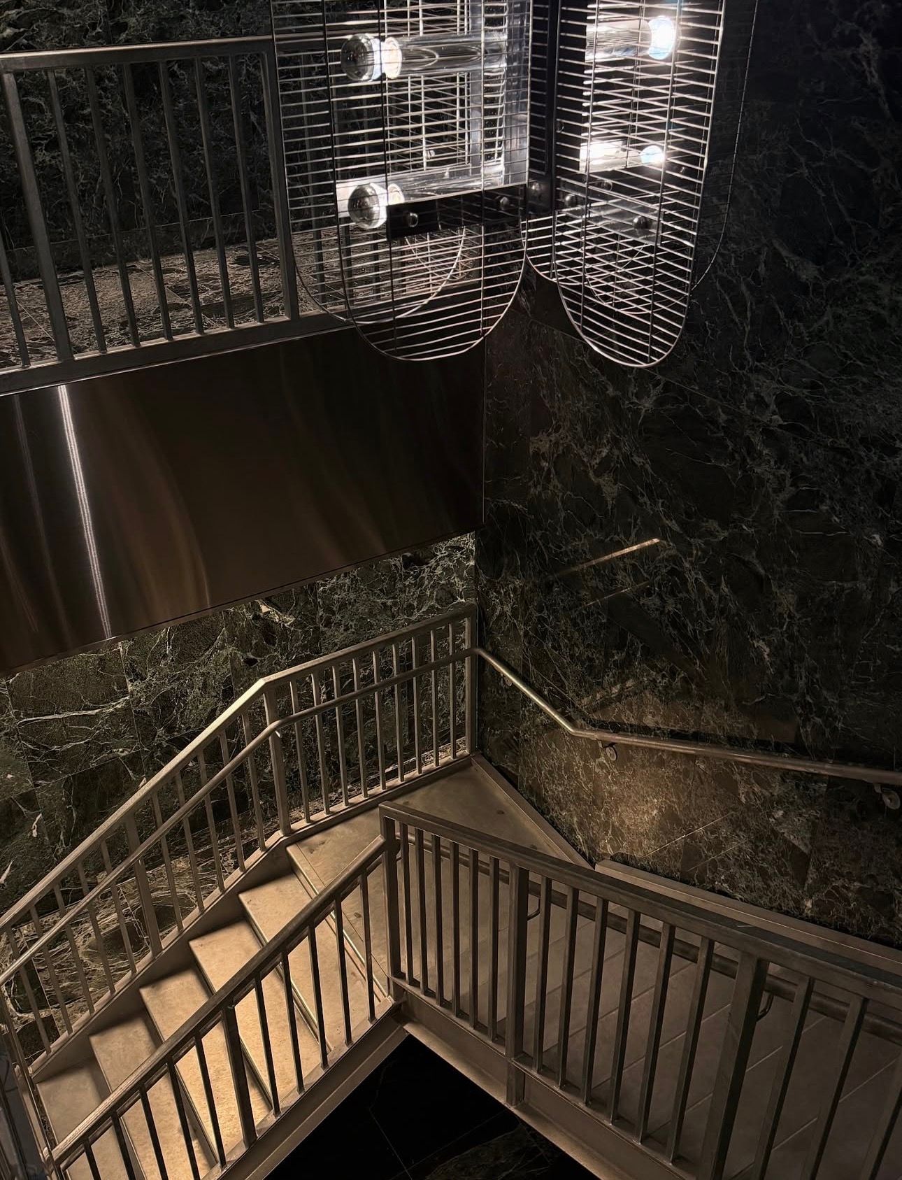 Dark green marble sink and backsplash with chrome faucets.