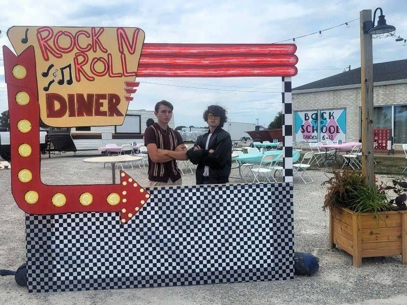 Two people pose in front of a 