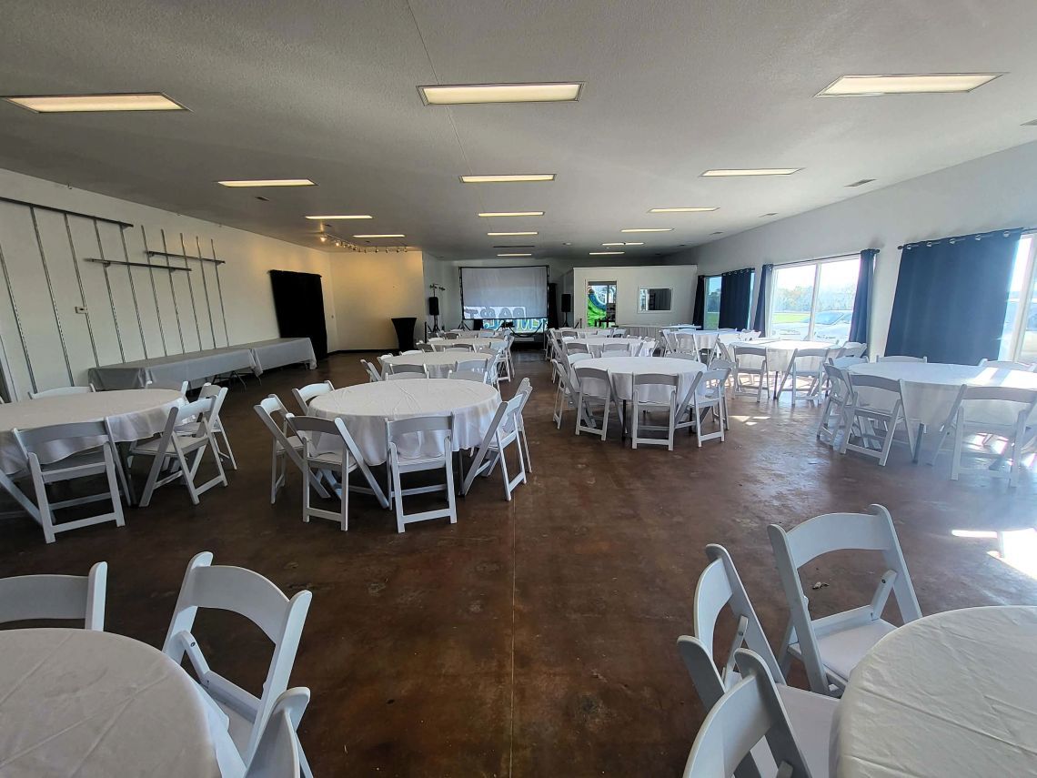Event hall with people seated at tables, crafting and browsing various displays.