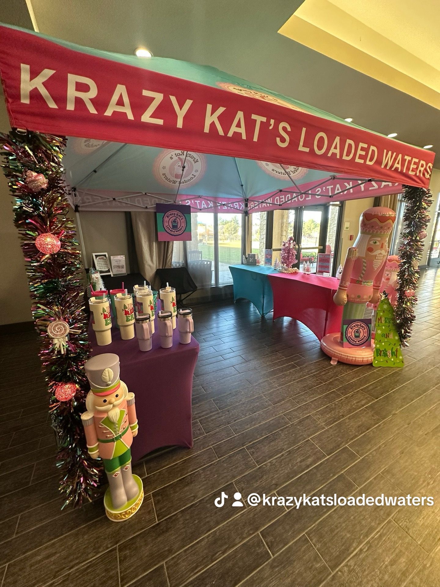 Pink vendor booth at an outdoor event. Products on display under a pink tent.