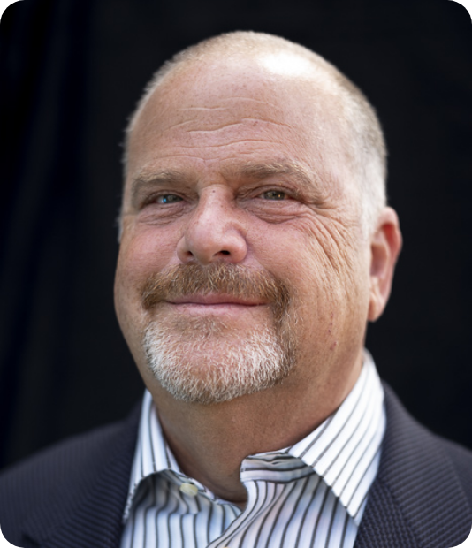 A man with a beard wearing a suit and striped shirt