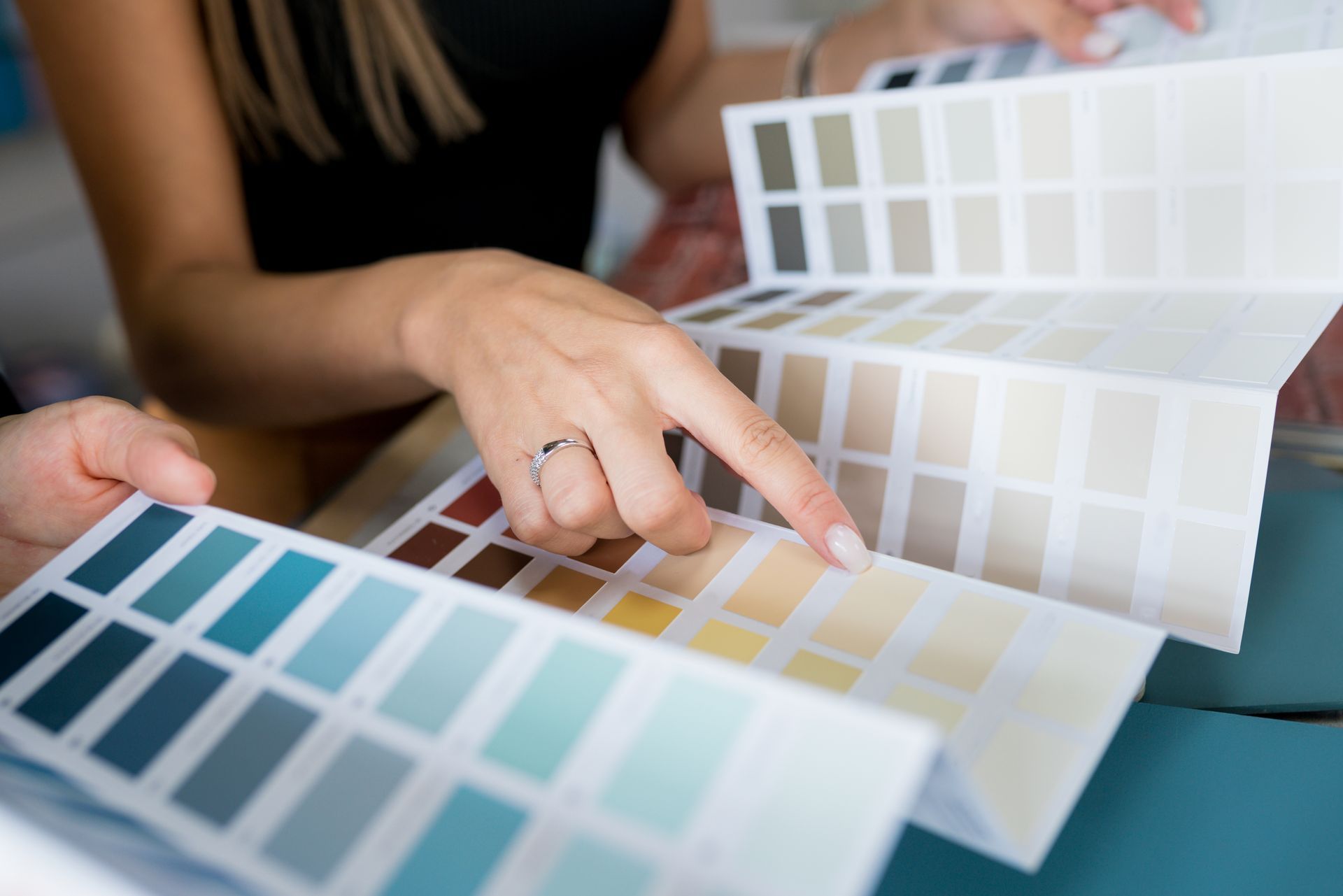 two people choosing paint colors from a book