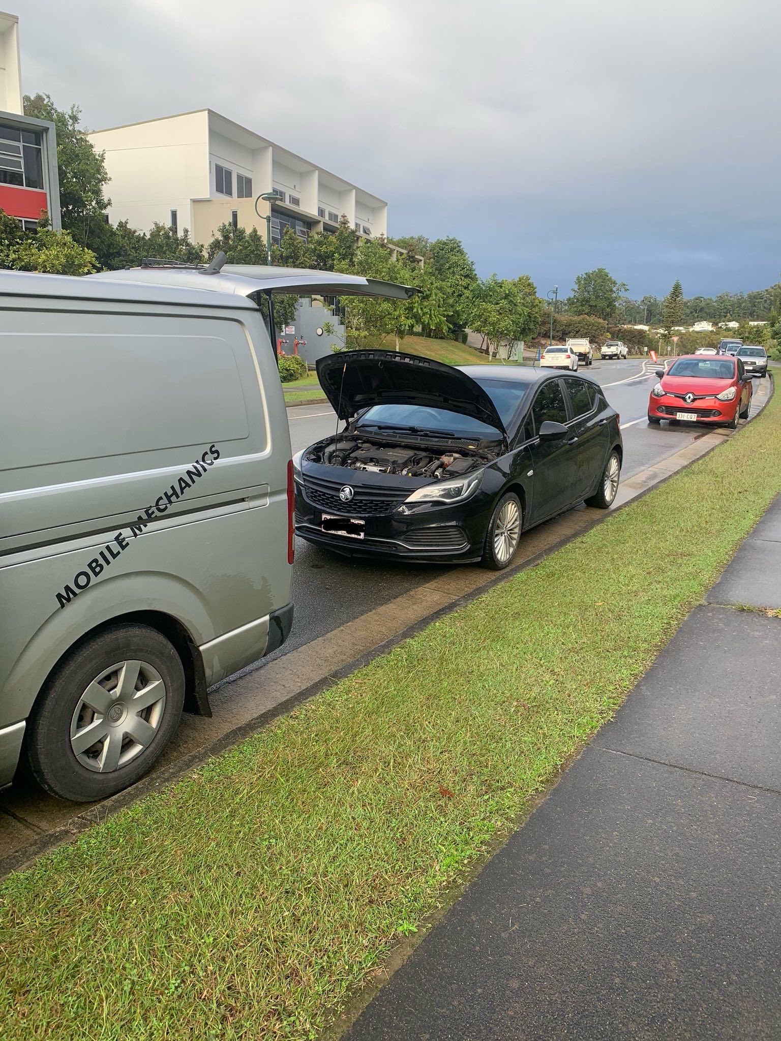 A Black Car With Its Hood Open Beside a Van and Curb on a Road — Calvin's Mobile Mechanics In Elanora, QLD