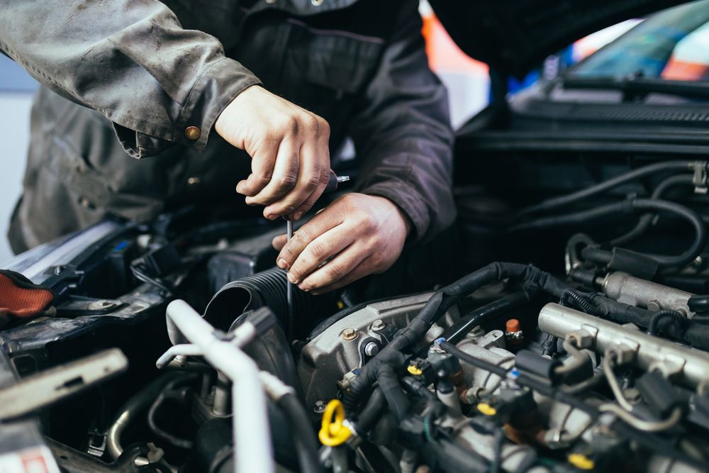 Mechanic Working on a Car Engine, Using a Screwdriver in a Garage — Calvin's Mobile Mechanics In Mudgeeraba, QLD