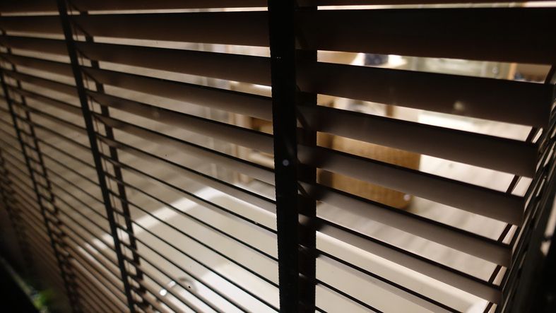 Evening sun light outside wooden window blinds Evening sun light outside wooden window blinds