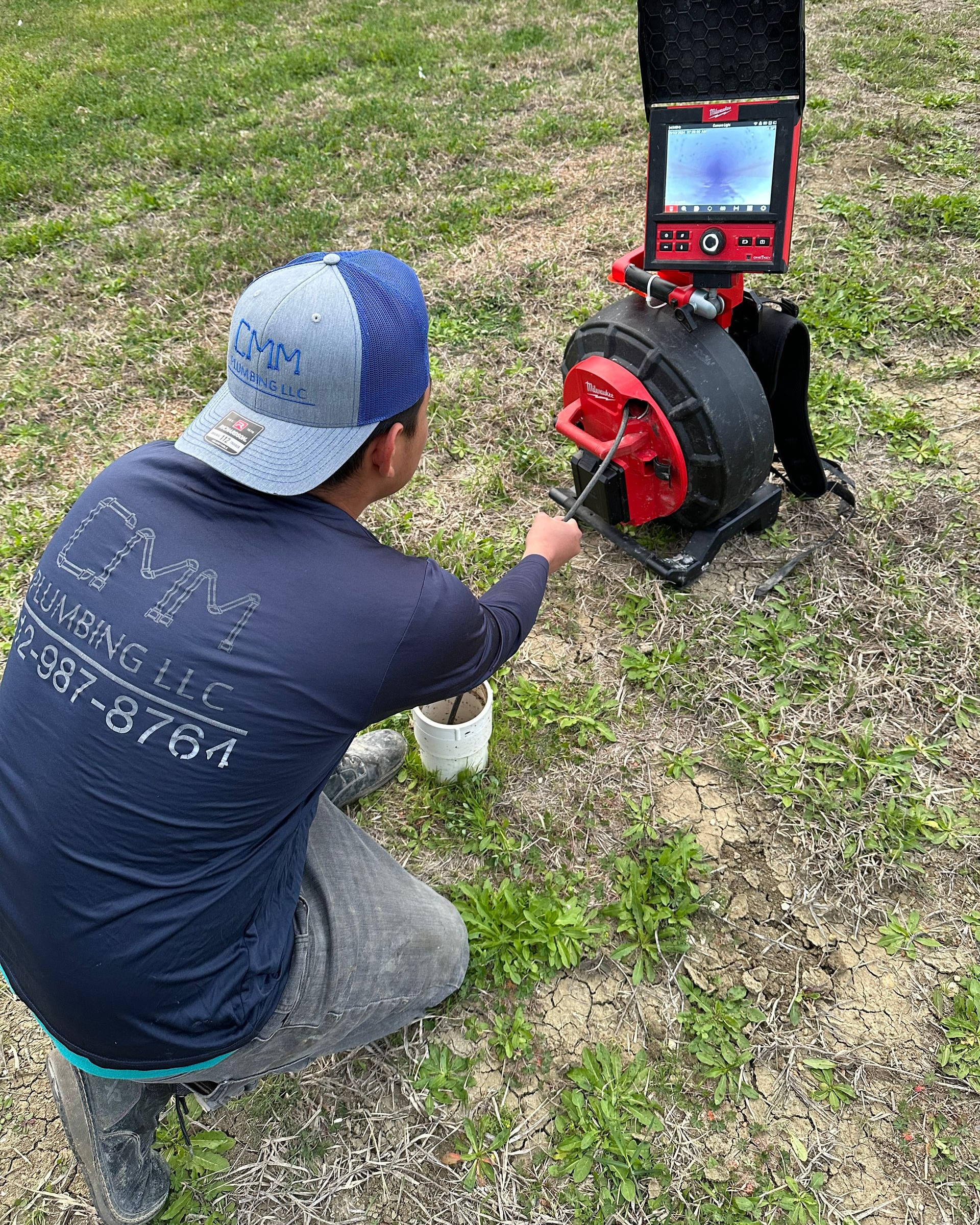 a man in a blue shirt is kneeling down in the dirt .