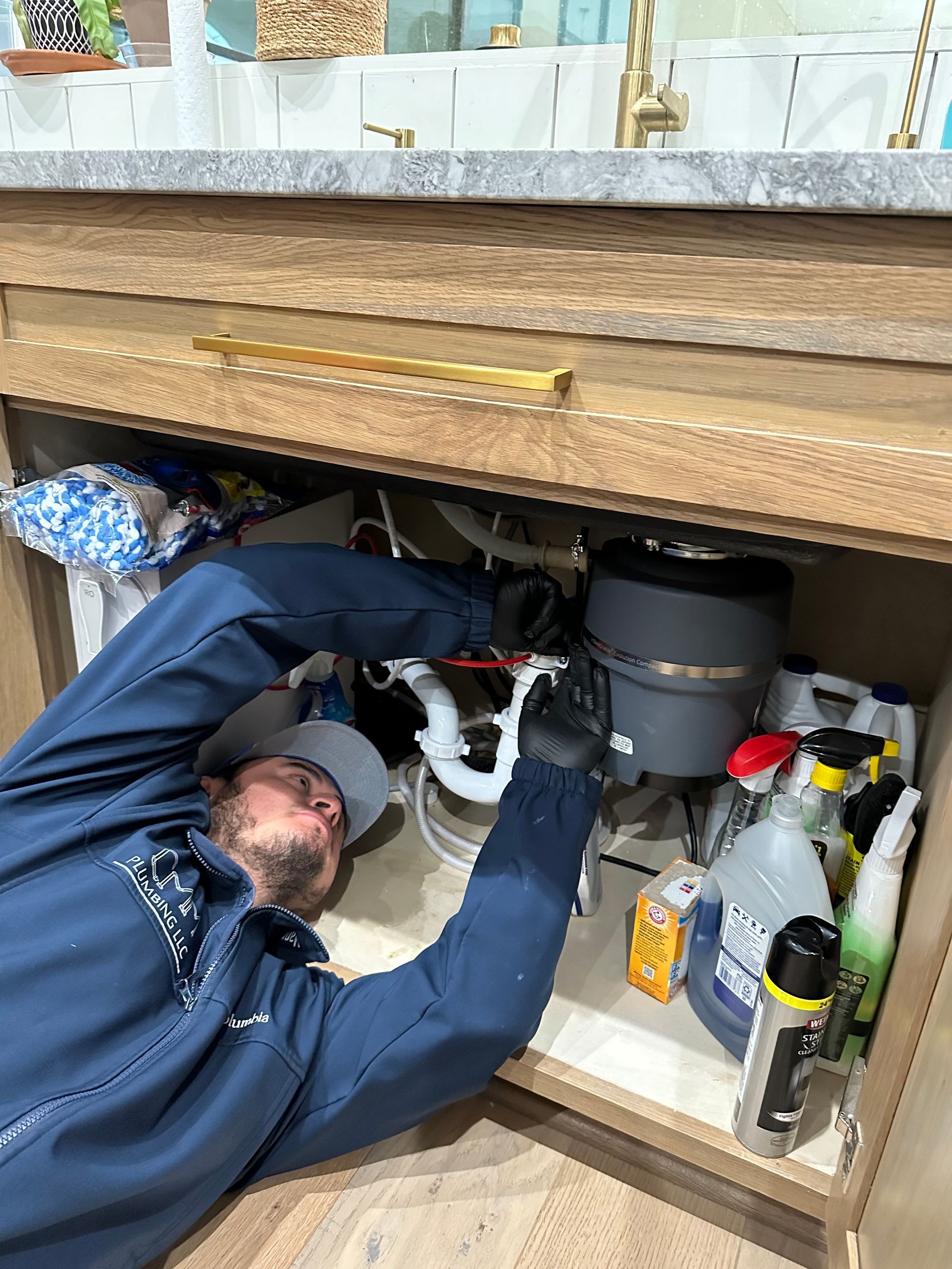 a man is working under a sink in a bathroom .