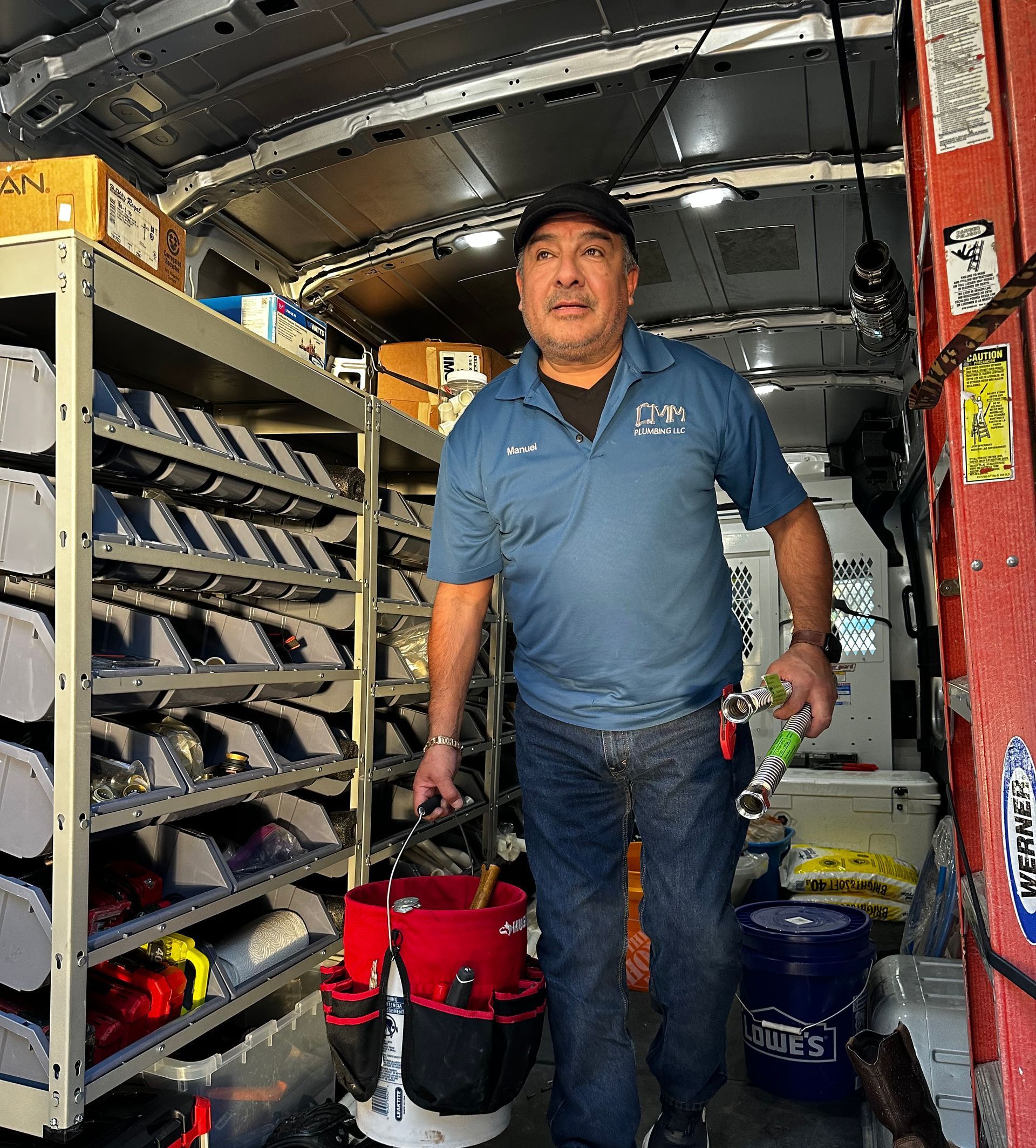 a man is standing in the back of a van holding a bucket