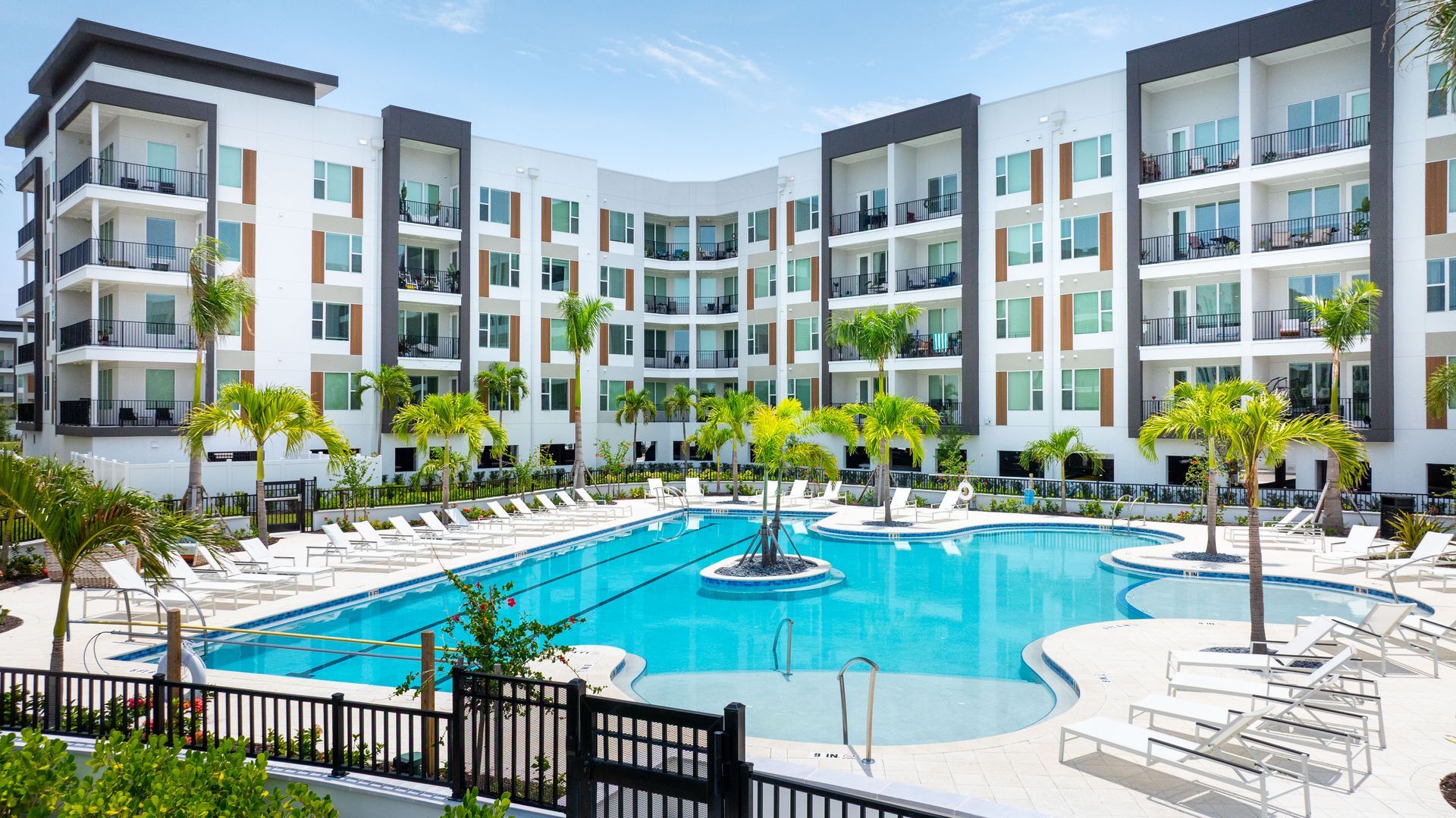 A large apartment building with a large swimming pool in front of it.