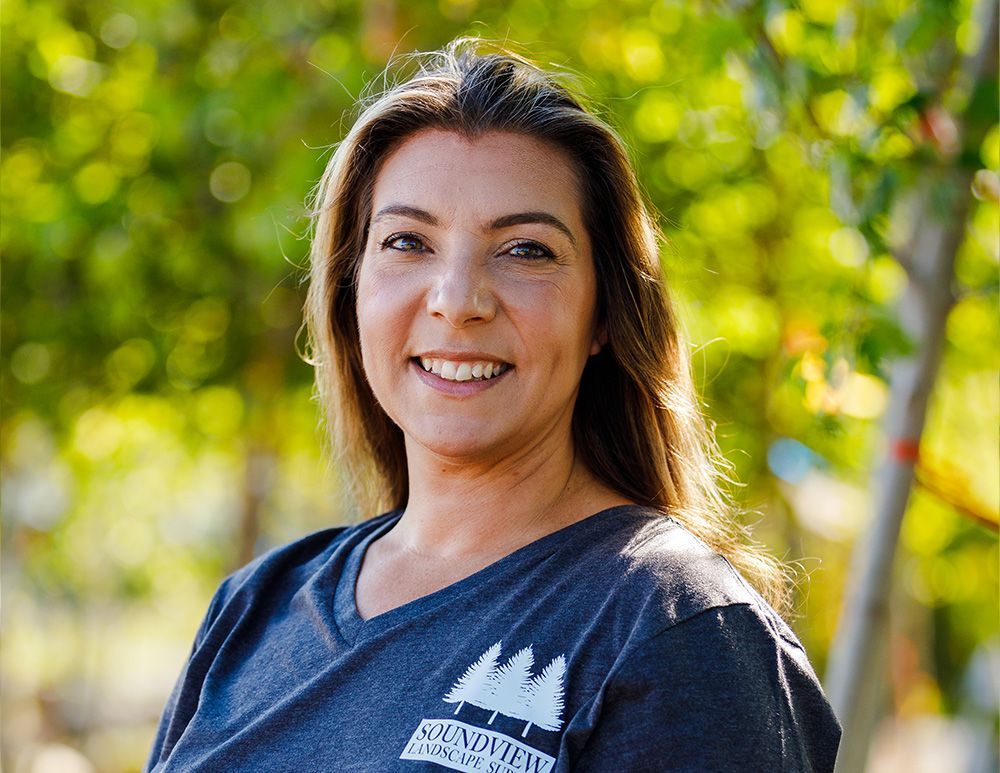 Woman with brown hair smiling, wearing a blue