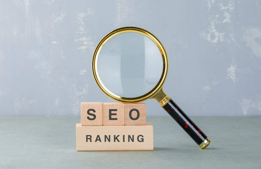 Magnifying glass leaning on top of wooden blocks that say SEO ranking.