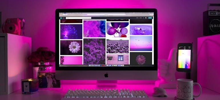 a laptop with images on the screen and purple lighting