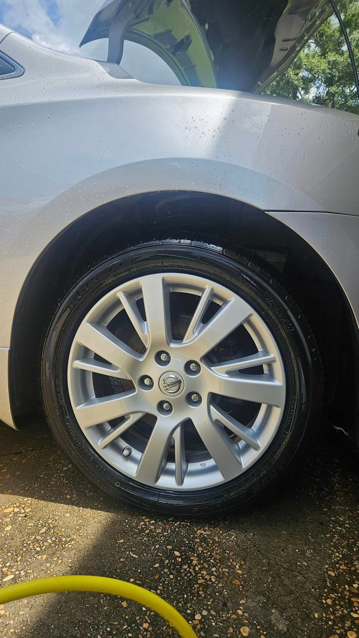 A close up of a car wheel with a yellow hose attached to it.