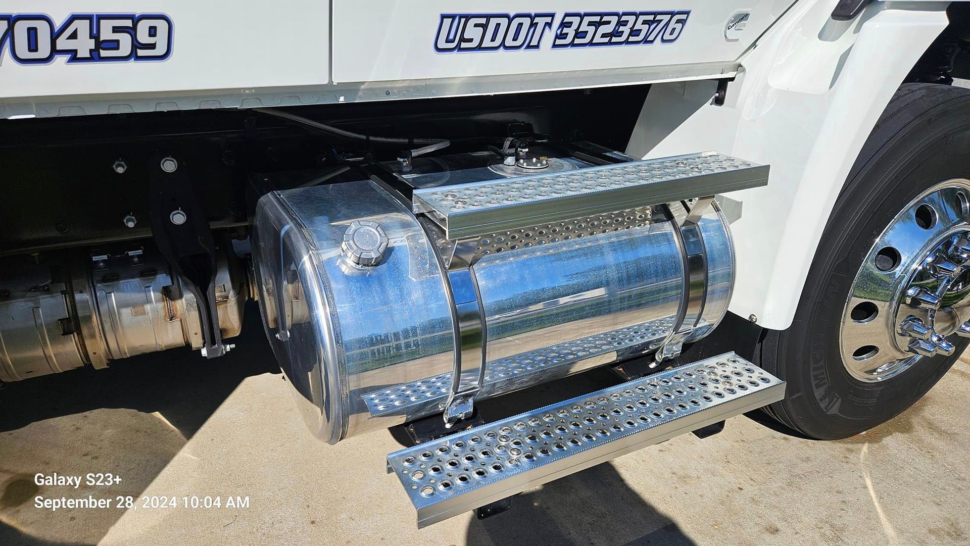 A white truck with a chrome fuel tank on the side