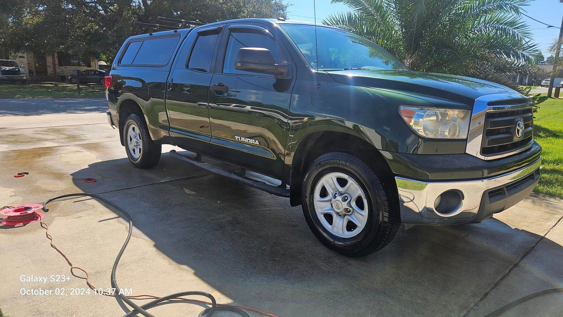 A black toyota tundra truck is parked in a driveway.