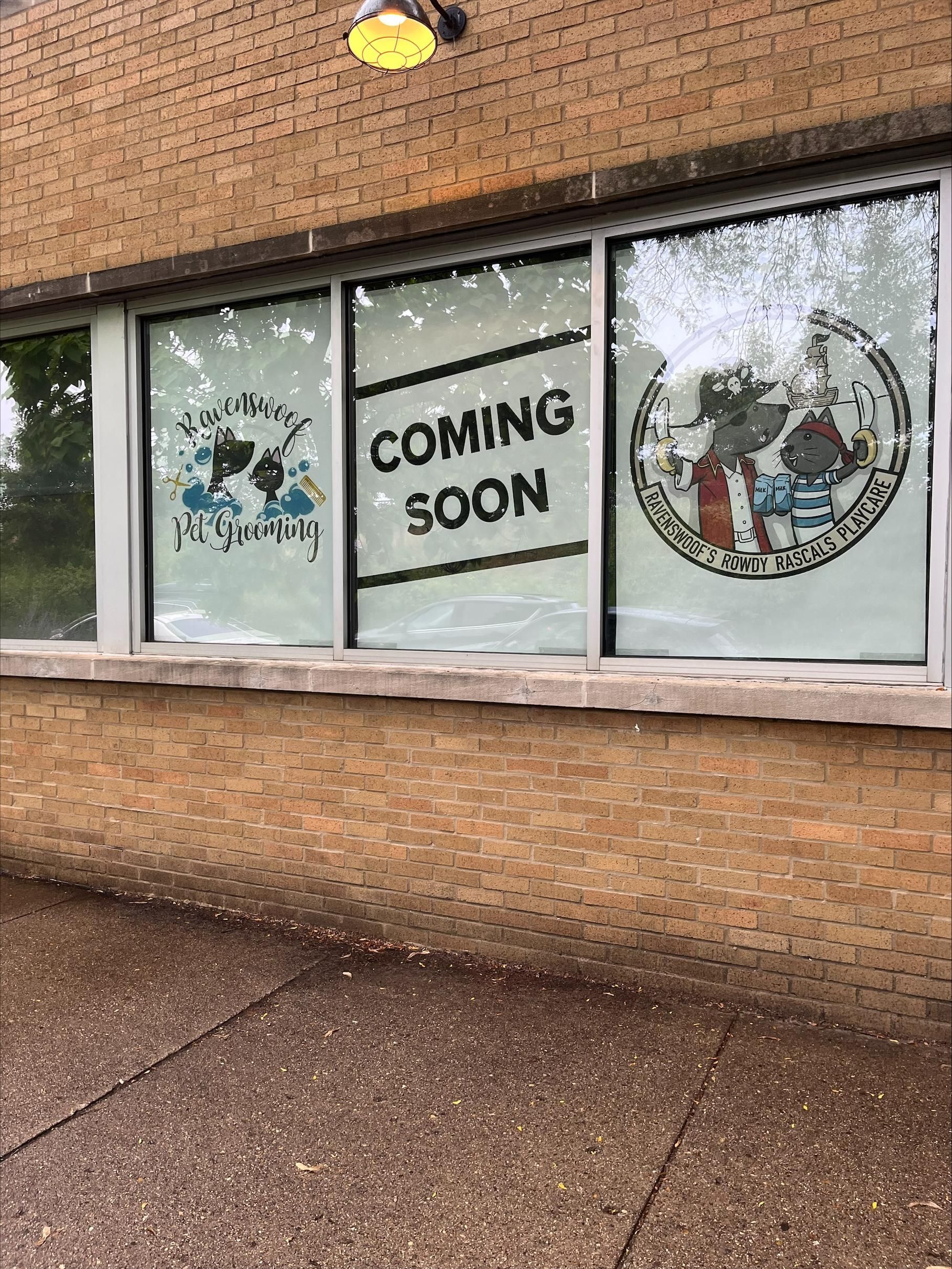 A brick building with a sign on the window that says `` coming soon ''.