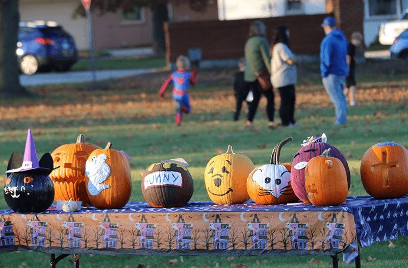 Decorated pumpkins on a table at an outdoor Halloween event. The Immanuel Difference | Immanuel Lutheran School | Belvidere, IL