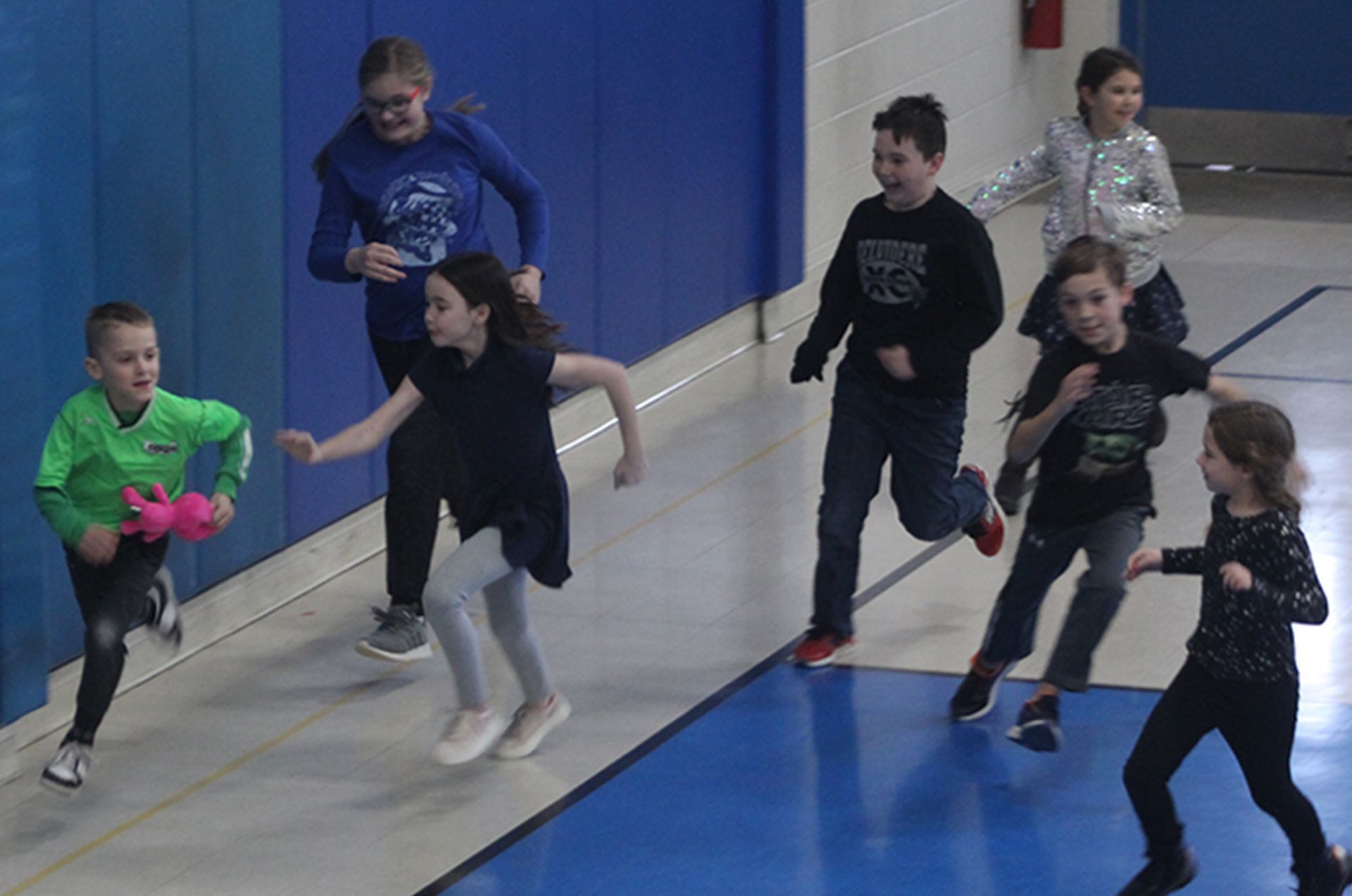 Children running in a gym; One child holds a pink stuffed animal.  Immanuel Lutheran School | Belvidere, IL