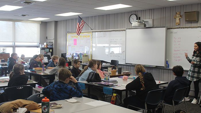 Classroom lesson: teacher at whiteboard, students seated at desks, American flag. Elementary School | Immanuel Lutheran School | Belvidere, IL
