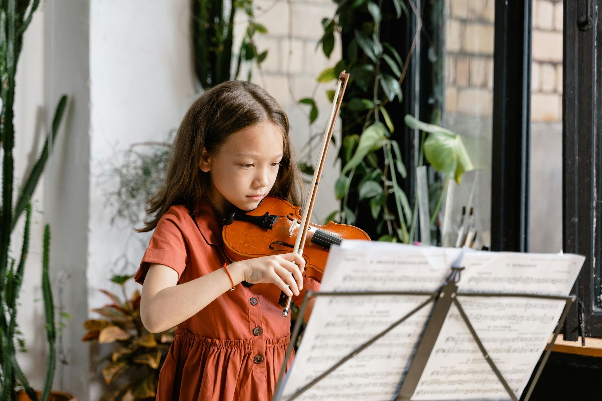 Girl playing a violin, looking at sheet music. Elementary School | Immanuel Lutheran School | Belvidere, IL