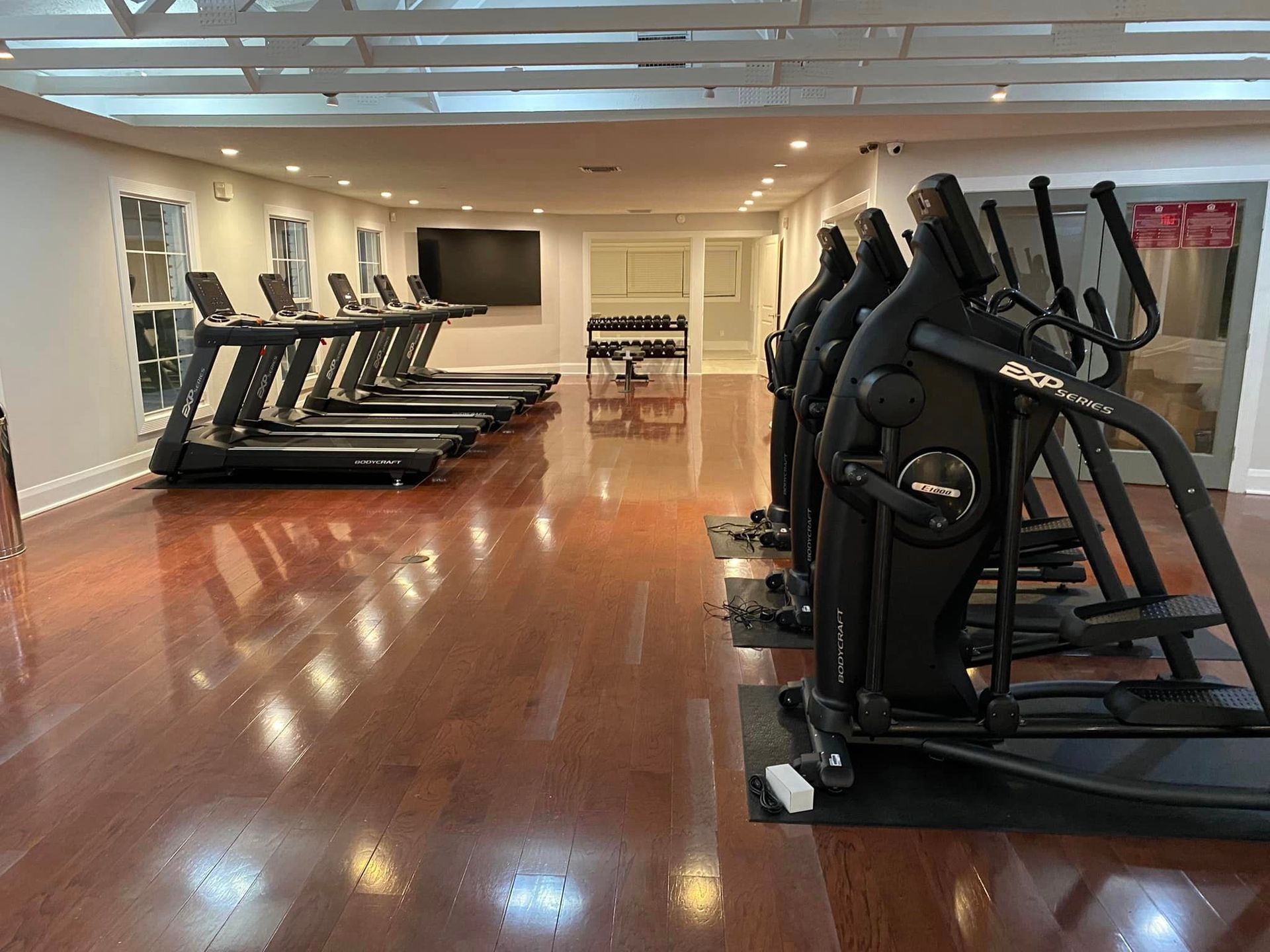 A gym with a lot of treadmills and ellipticals