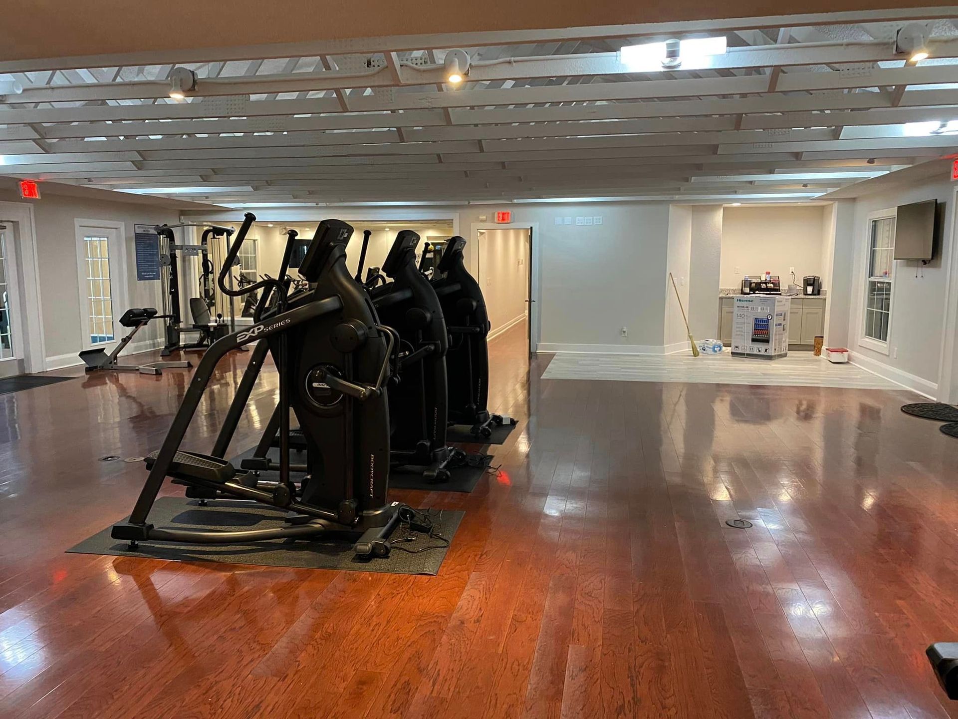 A gym with a lot of exercise equipment on the floor.