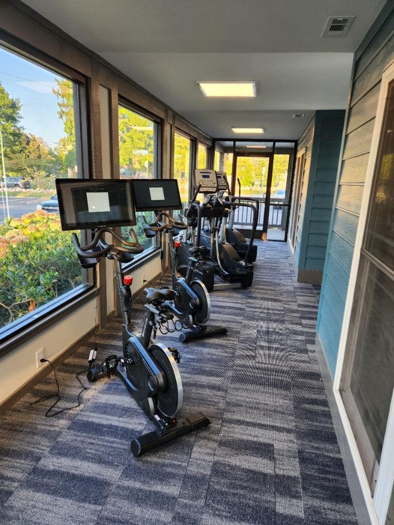 A gym with a lot of exercise bikes and treadmills.