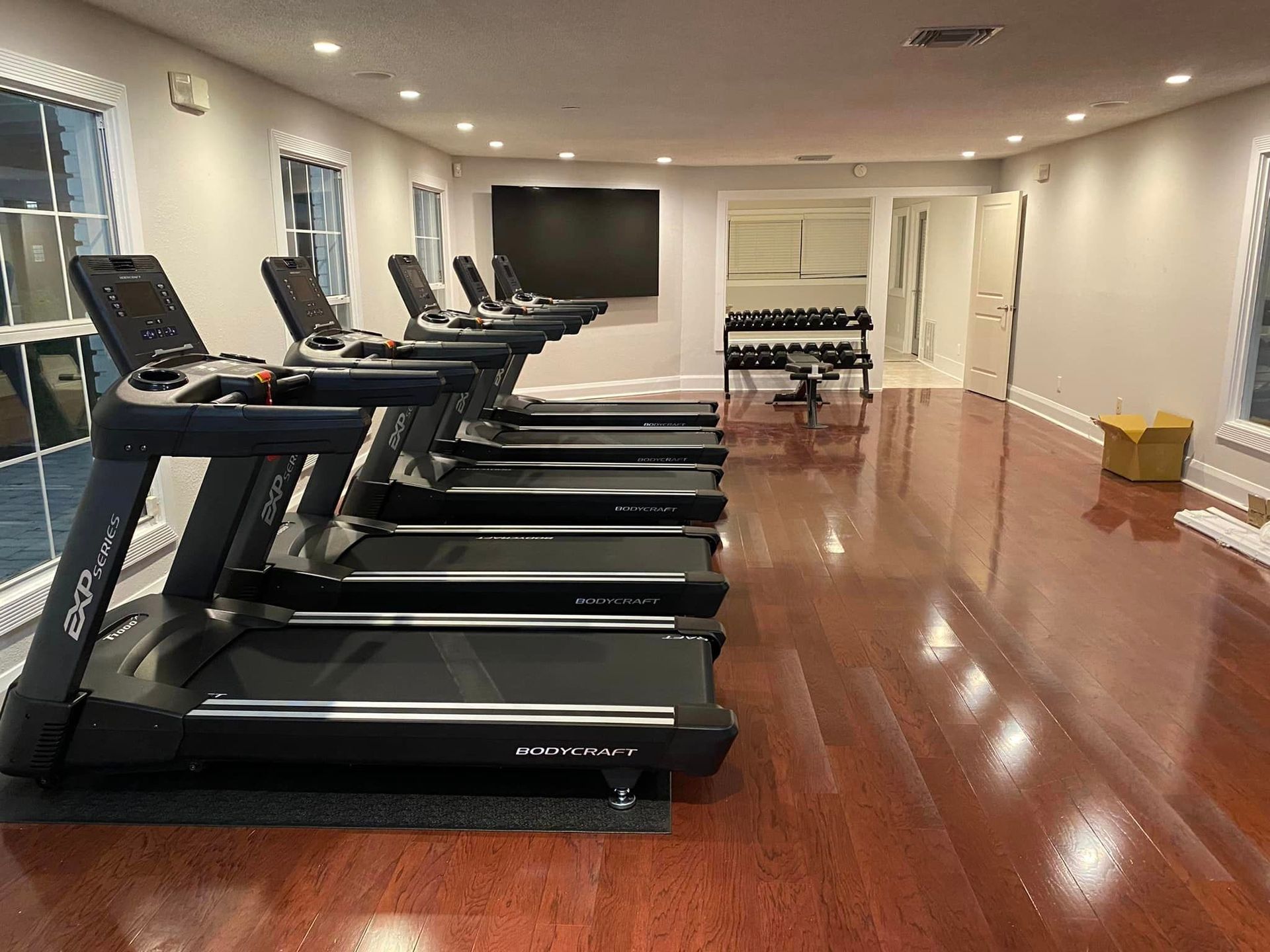 A row of treadmills are lined up in a gym.
