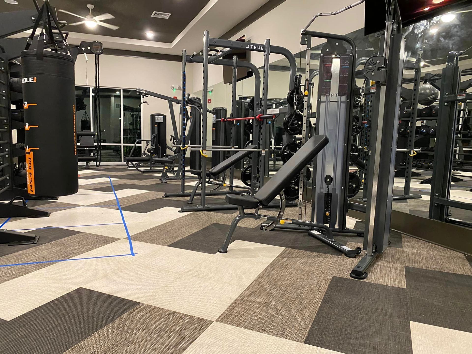 A gym with a lot of equipment and a checkered floor.