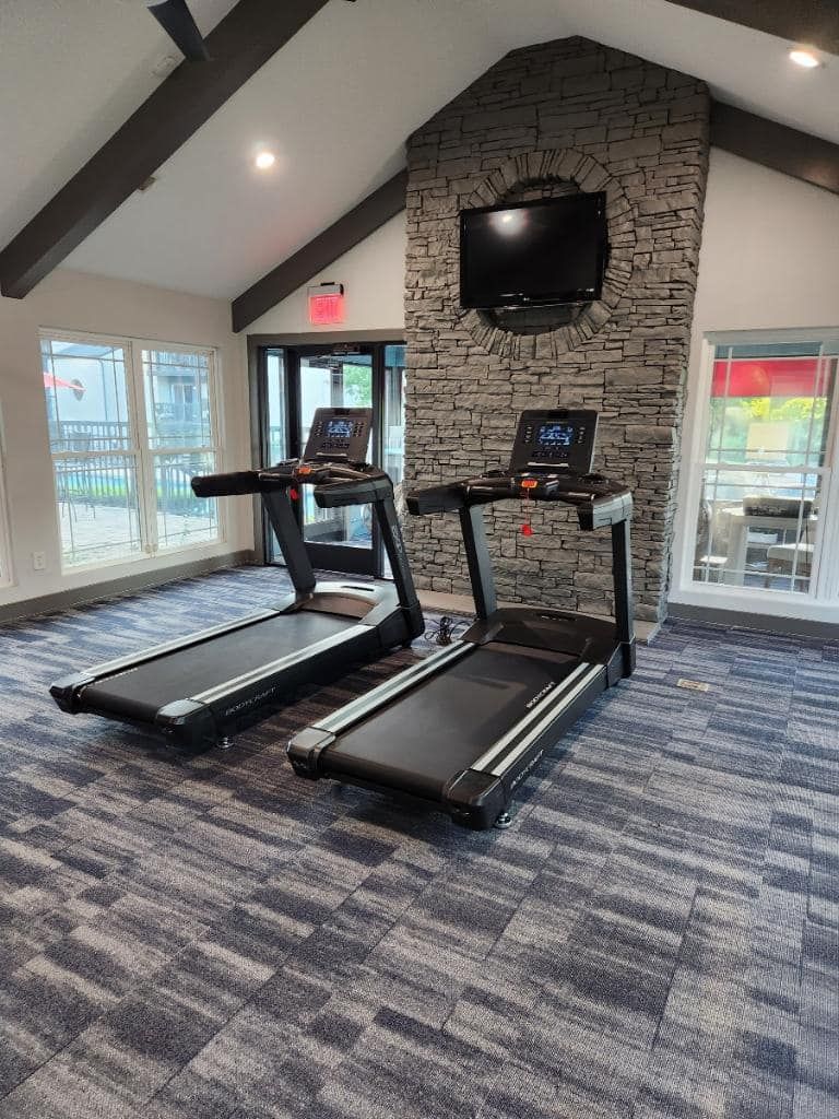 Two treadmills are sitting next to each other in a gym.