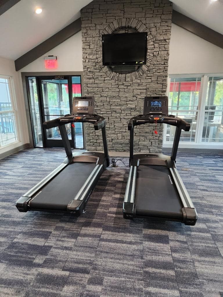 Two treadmills are sitting next to each other in a gym.